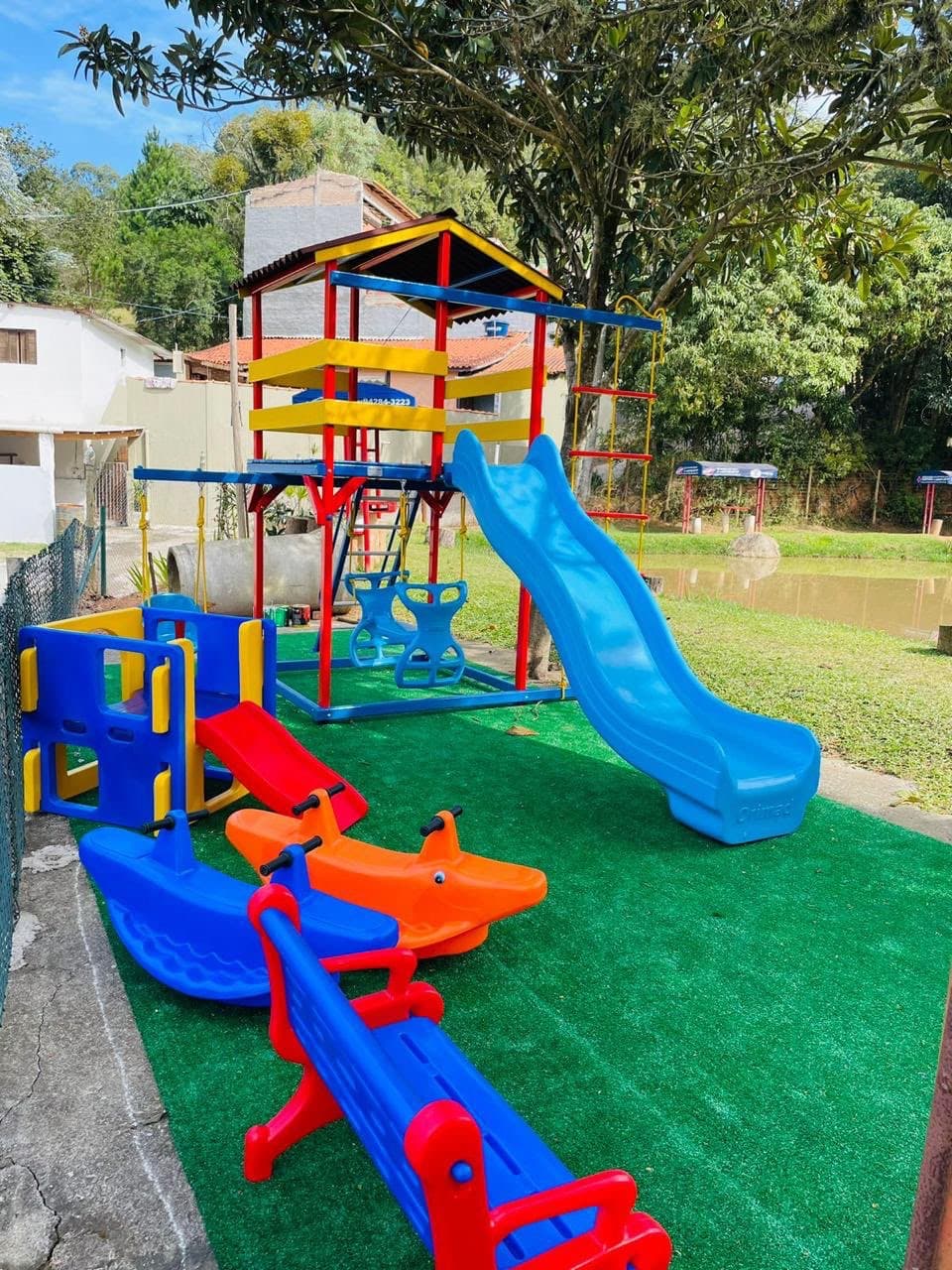 Playground da área Kids do Pesqueiro Arruda's, com escorregador, gangorras e balanços